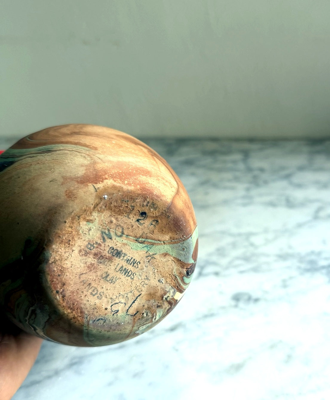Underside of vintage Nemadji pottery vase showing worn maker mark