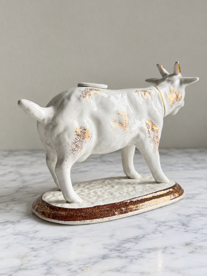 Vintage white ceramic cow creamer with worn gold accents, edited reverse view