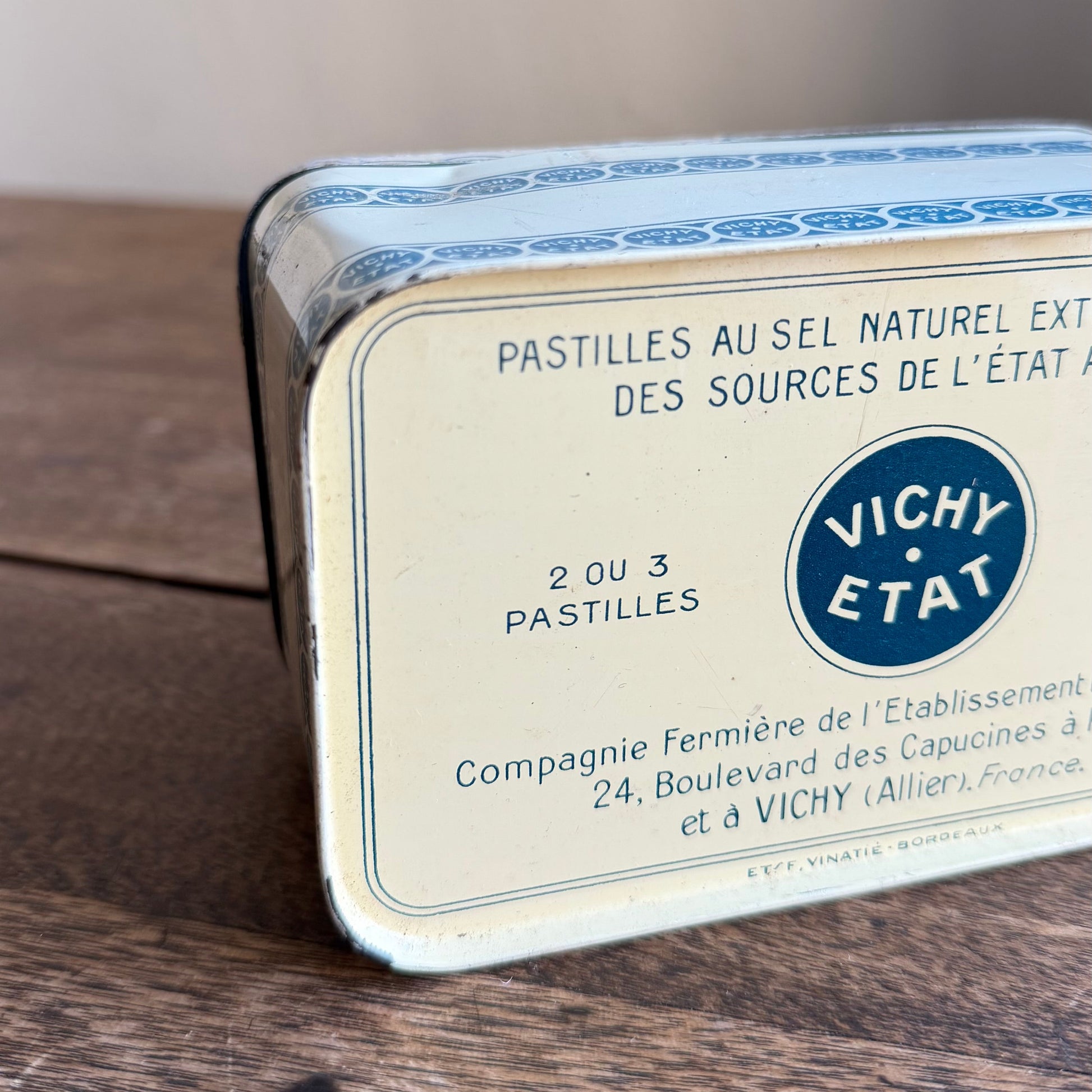 Vichy Etat tin on a wooden surface with a blurred background