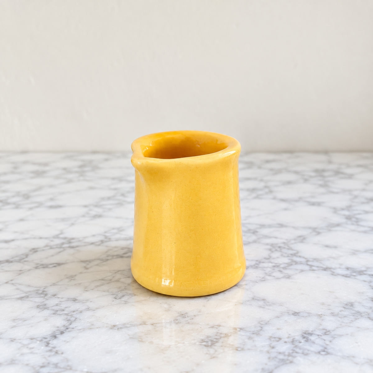 Vintage yellow ceramic handleless creamer with small pouring spout