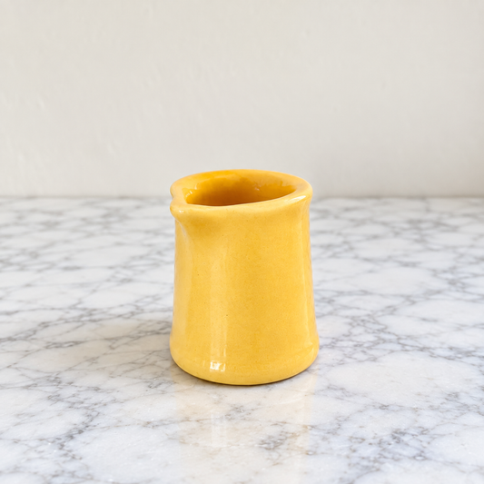 Vintage yellow ceramic handleless creamer with small pouring spout